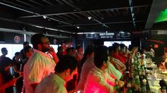 a group of people standing around at a bar