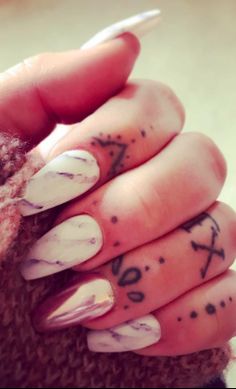 a woman's hand with some tattoos on it