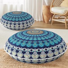 two blue and white pillows sitting on top of a rug