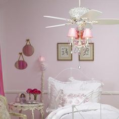 a bedroom with pink walls and chandelier