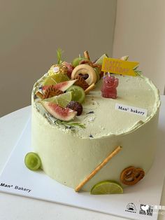 a cake with fruit and pretzels on it sitting on top of a table