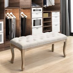 a white bench sitting in front of a closet filled with clothes