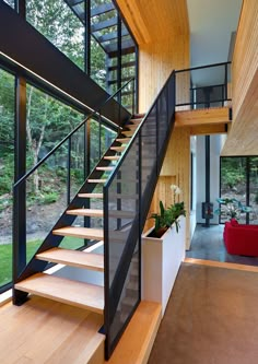 there is a stair case in the middle of this room with glass walls and wood flooring