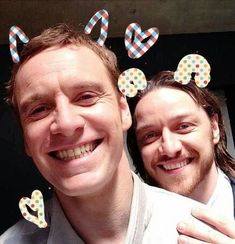 two men are posing for the camera with mickey ears on their heads