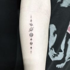 an arm tattoo with planets and stars on the left side of it, in black ink