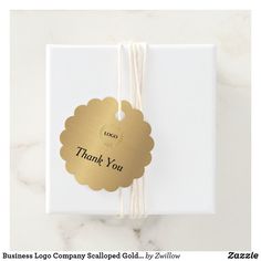 a thank you tag attached to a white gift box with gold foil on the top