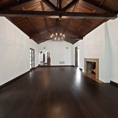 an empty room with wood floors and white walls