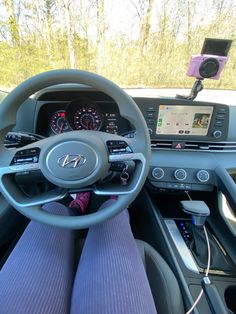 the interior of a car with steering wheel, dashboard and display screen showing various electronic devices