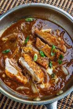 a pan filled with meat and sauce on top of a table