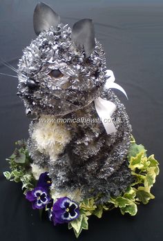 a cat made out of tin foil and flowers