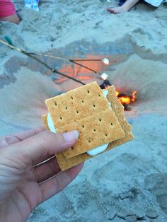 someone is holding crackers in front of a campfire