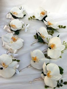 white flowers and greenery are laid out on a bed