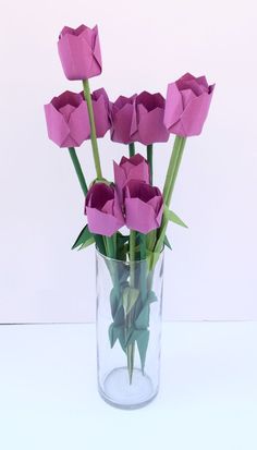 a vase filled with purple flowers on top of a table