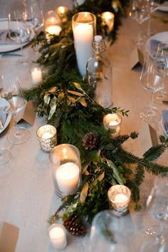 the table is set with candles and greenery for an elegant christmas dinner or reception