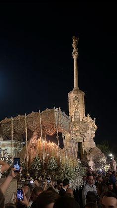 a group of people taking pictures with their cell phones in front of an elaborately decorated building