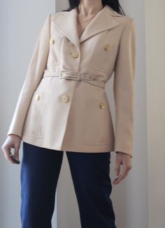 Beautiful vintage tailoring 70s cream pure wool blazer. Four front pockets, amazing buttons. The belt is not in perfect condition, it can be easily replaced with a leather one or with a printed silk scarf. Fully lined. Excellent vintage conditions, two very tiny signs of age as you can seen in the last photo. Best fit size 6 and 8 uk. (XS/S) Shoulder to shoulder 38 cm Bust 45 cm Waist 41 cm Hips 46 cm Length 63 cm Model's size 6 uk, h 163 cm. Cream Wool Blazer For Business, Beige Business Blazer With Buttons, Classic Cream Double-breasted Blazer, Cream Business Blazer With Double Button Closure, Classic Winter Blazer With Belt Loops, Business Cream Blazer With Double Button Closure, Cream Double Button Blazer For Business, Cream Blazer With Double Button Closure For Business, Office Beige Blazer With Buttons