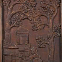 carved wooden panel with tree and man in front of building