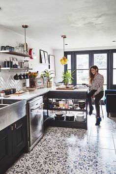 a woman standing in the middle of a kitchen