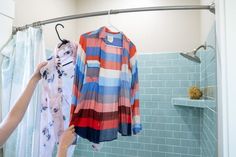 a woman is hanging clothes in the shower