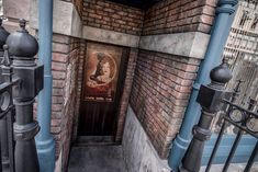 an entrance to a building with a portrait on the door and iron fence around it