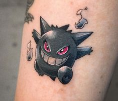 a tattoo on the leg of a person with a black and red pokemon pikachu