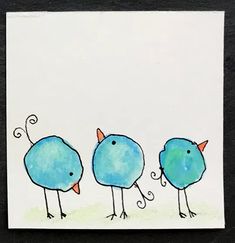 three blue birds are standing in a row on a white card with black edges and one bird has orange beaks