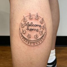 a woman's legs with a tattoo saying welcome home