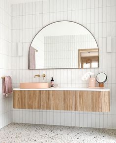 a bathroom with a sink, mirror and towel rack on the wall in front of it