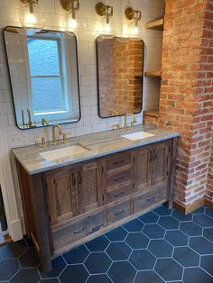 a bathroom with double sinks and brick wall