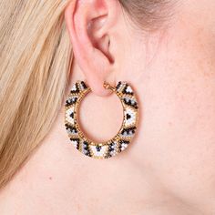 Experience the bold elegance of Abi earrings! Woven with black, gold, and white Miyuki beads, these indigenous-inspired hoop earrings will instantly elevate any look. Add a classic touch to your wardrobe with Abi! White Round Hoop Earrings For Festival, White Hoop Earrings For Festival, White Beaded Earrings With Black Beads, Traditional White Hoop Earrings, Lifestyle Posing, Social Projects, Jewelry Workshop, Family Support, Miyuki Beads