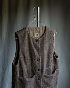 Men's hemp and wool warm vest DUST This vest is made of heavy weight material -- composition of natural undyed hemp and wool, thick and warm, with alive visible texture. Lining is made of linen. Each vest is gathered from remnants of fabric, so each one has unique pattern. Hand dyed with black tea and iron to achieve warm grey shade, slightly imperfect. Vest has two big random shaped patch pockets. Buttons are made of cherry wood, hand carved and hand dyed. Vest details, pockets and buttonholes are hand stitched with natural linen thread. Total length is ~65cm. Plaid Vest Men, Mens Wool Vest, Canvas Vest, Tweed Waistcoat, Winter Knitwear, Linen Thread, Mens Vests, Wool Vest, Ethical Clothing