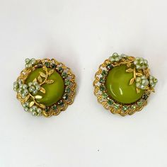 This gorgeous vintage set includes a necklace with a double strand of pale green shimmery faux pears and darker green rhinestones that encircle a chartreuse central shiny simulated stone and matching clip-on earrings. Green Jeweled Round Earrings, Vintage Green Evening Jewelry, Vintage Green Jeweled Earrings, Green Jewelry For Evening - May Birthstone, Clip-on Costume Jewelry For Vintage Events, Green Jeweled Evening Jewelry, Green Clip-on Jewelry For Evening, Green Jeweled Jewelry For Evening, Green Clip-on Jewelry For Party