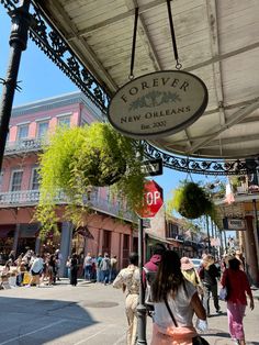 people are walking under an awning on the sidewalk in front of shops and restaurants