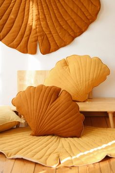 two large leaf shaped pillows sitting on top of a wooden floor