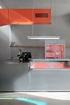 a kitchen with an orange ceiling and white counter tops in front of a large window