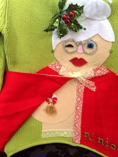 a close up of a person wearing a green sweater with a snowman on it