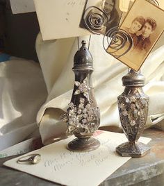 two silver vases sitting on top of a table next to an open notepad