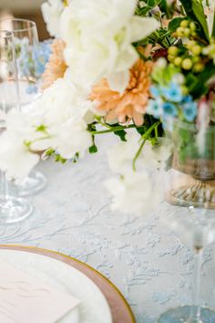 the table is set with white and blue flowers