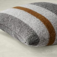 a gray and brown striped pillow sitting on top of a table