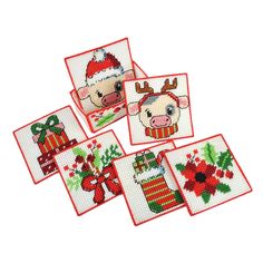 four cross stitch christmas coasters with animals and presents on them, all decorated in red and green