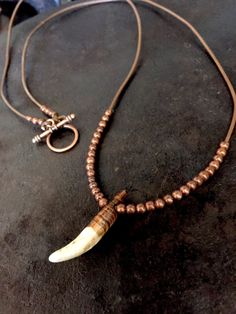 Wolf tooth Necklace on a brown  leather cord with copper beads. This necklace is made with a wolf tooth that is approximately 1 and 1/2" long. Each piece of jewelry I make is made with specific intention and symbolism. Indigenous peoples recognize the wolf as a guide and teacher and this necklace was made to honor all our teachers. I also used a copper toggle on this necklace. Copper has been used as a healing mineral since ancient times. When copper is worn next to the body it is absorbed and is known to help decrease inflammation such as arthritis and carpal tunnel. Copper is also a conductor of energy, intensifying the properties of stones and crystals around it. The cord on this necklace is brown leather. The leather I use comes from a Native American leather supplier.  Every wolf toot Fang Necklace, Wolf Tooth Necklace, Tooth Jewelry, Wolf Tooth, Wolf Teeth, Hemp Necklace, Teeth Jewelry, Tooth Necklace, Carpal Tunnel