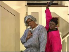 two women standing next to each other holding cell phones