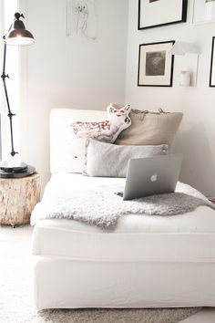 a laptop computer sitting on top of a white couch