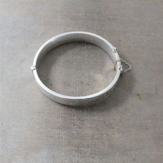 "A beautifully engraved scrollwork graces this bangle on the front; the back is without decoration. The bracelet, made in Chester, England in 1960, is fully hallmarked on the interior with the English standard for sterling. The lovely piece opens with and closes with a click, it has a safety chain for added security. Bracelet (closed): approx. 2 1/4 x 2 1/16\" width 7/16\" (14m) interior perimeter 6 3/4\" BB005 ✦All of our vintage bracelets ship with complimentary insurance✦ ✤Our entire selectio Etched Sterling Silver Bangle Bracelet For Wedding, Ceremonial Engraved Sterling Silver Bracelet, Stamped Sterling Silver Bangle For Wedding, Sterling Silver Stamped Bangle For Wedding, Silver Bangle Bracelet With Engraving Option, Ceremonial Engraved Bangle Cuff Bracelet, Heirloom Etched Bangle Cuff Bracelet, Sterling Silver Engraved Bangle For Ceremonial Occasions, Engraved Bangle Cuff Bracelet For Wedding