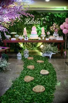 a table with cake and flowers on it in front of a green wall that says hello kitty