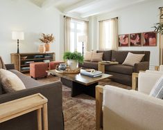 a living room with couches, chairs and a coffee table in front of a window