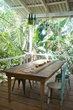 a wooden table sitting on top of a wooden floor next to a lush green forest