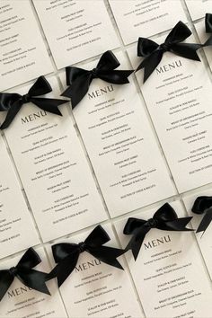 the menus are lined up with black bows on each one side and white paper in the middle