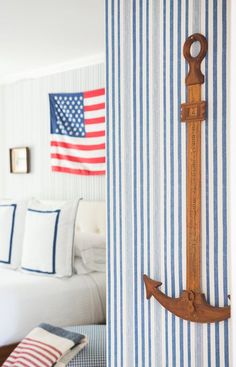 an anchor hangs on the wall next to a bed in a room with blue and white striped walls