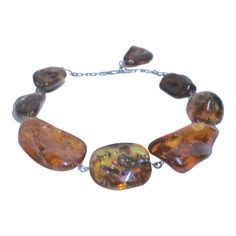 This is part of Chairish’s Fine Jewelry assortment.  The exquisite rare massive ancient natural Baltic "dollop" of fossilized  tree resin, known as Amber, Collar Necklace has several unusual ancient inclusions that have been forever  preserved inside which makes it extremely special.  This example is a fine piece in terms of its huge size, inclusion,  differing colors, clarity and overall aesthetic appeal.   Eight graduated Amber pieces from Huge lighter color to large darker color created in the 20th century into a necklace with sterling contemporary loop connections ending in a 925 sterling chain clasp with a large Amber dangle closure.   It has a beautiful glowing luster shaped with Inclusions and  fissures in the varied coloration and shape of each piece as  a beautiful aged specimen. Standard Oil, Baltic Amber Necklace, Amber Necklace, Baltic Amber, Collar Necklace, Dark Colors, 18th Century, Stylish Women, Amber